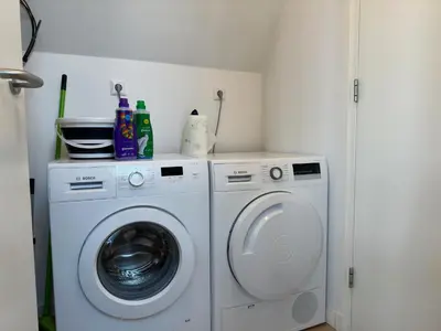 a laundry room with a washer and dryer at Duinroos vlakbij strand in Egmond aan Zee