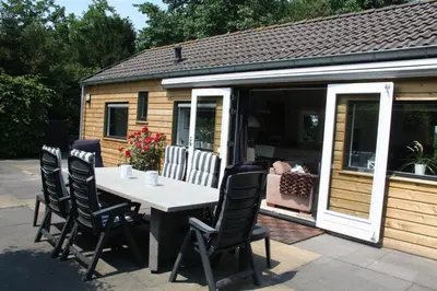 a table and chairs in front of a house at Bungalowpark Mooyeveld in Egmond-Binnen