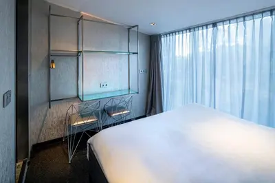 a bedroom with a large white bed and a window at Diamond Capsule Hotel Amsterdam South in Amstelveen