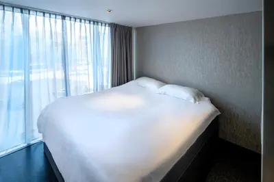 a large bed in a room with a large window at Diamond Capsule Hotel Amsterdam South in Amstelveen