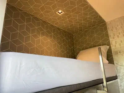 a bedroom with a bed with a hexagonal wall at Diamond Capsule Hotel Amsterdam South in Amstelveen