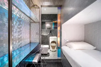a small room with a bed and a bathroom at Diamond Capsule Hotel Amsterdam South in Amstelveen