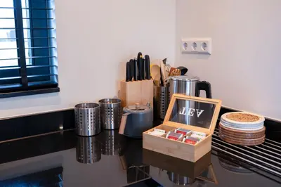 a kitchen counter with a table with a box on it at 8 persons waterfront Villa Tulpenacker in Roelofarendsveen