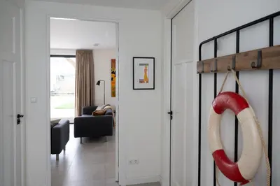 a living room with a red and white oar hanging from a door at 8 persons waterfront Villa Tulpenacker in Roelofarendsveen