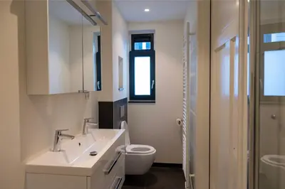 a white bathroom with a toilet and a sink at 8 persons waterfront Villa Tulpenacker in Roelofarendsveen
