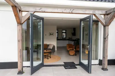 a room with glass doors and a living room at 8 persons waterfront Villa Tulpenacker in Roelofarendsveen