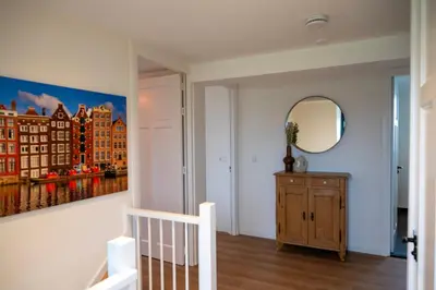 a room with a staircase and a painting on the wall at 8 persons waterfront Villa Tulpenacker in Roelofarendsveen
