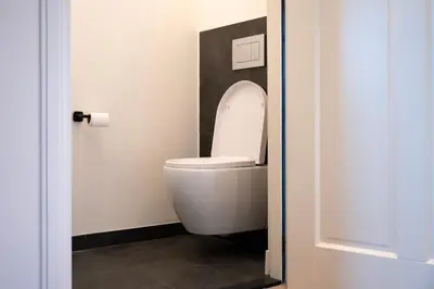 a bathroom with a toilet with the lid up at 8 persons waterfront Villa Tulpenacker in Roelofarendsveen