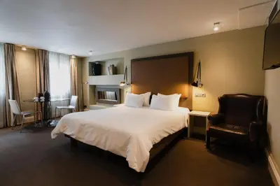 a hotel room with a large bed and a chair at Hotel Roemer Amsterdam in Amsterdam