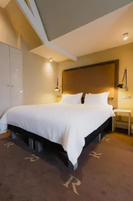 a large bedroom with a large white bed in a room at Hotel Roemer Amsterdam in Amsterdam