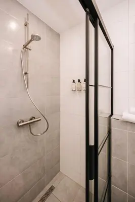 a shower with a glass door in a bathroom at Casa la Vida Beach House in Zandvoort