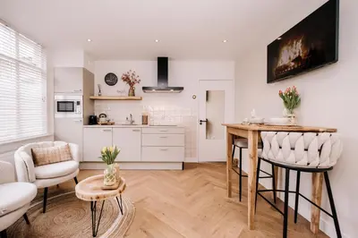 a kitchen and living room with a table and chairs at Casa la Vida Beach House in Zandvoort