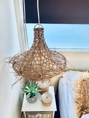 a rattan light hanging over a table with plants at Apartment Sunflower Zandvoort in Zandvoort