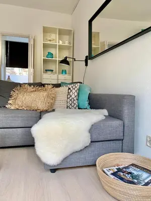 a living room with a couch and a mirror at Apartment Sunflower Zandvoort in Zandvoort