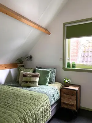 a bedroom with a green bed and a window at Apartment In de Wolken in Oostwoud