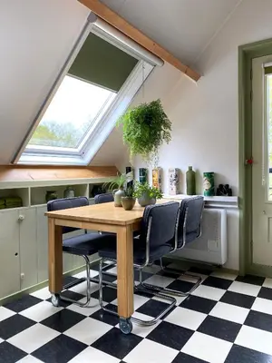 a dining room with a table and chairs and a window at Apartment In de Wolken in Oostwoud