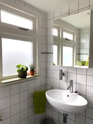 a white bathroom with a sink and a mirror at Apartment In de Wolken in Oostwoud
