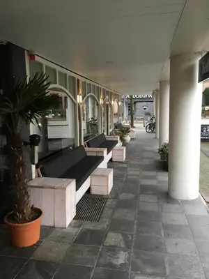 a row of benches sitting outside of a building at Hotel Restaurant de Jonge Heertjes in Aalsmeer