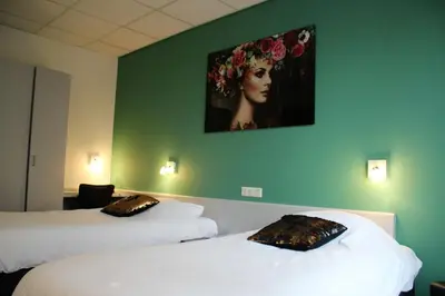 a room with two beds and a painting on the wall at Hotel Restaurant de Jonge Heertjes in Aalsmeer
