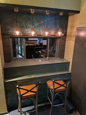 a restaurant with two chairs and a bar with lights at Hotel Restaurant de Jonge Heertjes in Aalsmeer