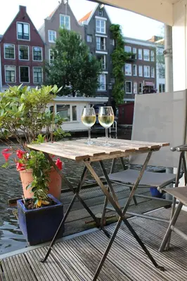 two glasses of wine sitting on a wooden table at Houseboat Orpheus in Amsterdam