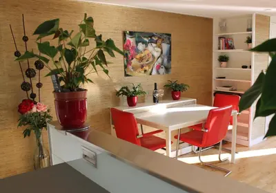a kitchen with a white table and red chairs at Houseboat Orpheus in Amsterdam