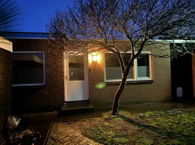 a house with a tree and a white door at Luxe woning Bubbles! Met airco en Parkeren op eigen grond in Castricum
