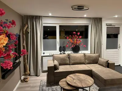 a living room with a couch and a table at Luxe woning Bubbles! Met airco en Parkeren op eigen grond in Castricum