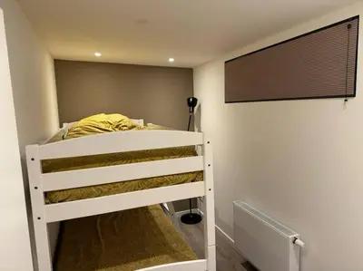 a white bunk bed in a room with a wall at Luxe woning Bubbles! Met airco en Parkeren op eigen grond in Castricum