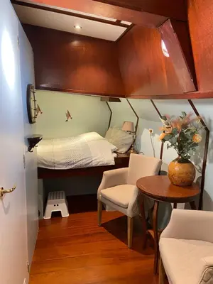 a small room with a bed and a table and chairs at Klipper Johanna in Monnickendam