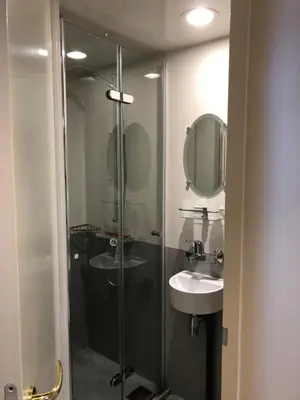 a bathroom with a shower and a sink and a mirror at Klipper Johanna in Monnickendam