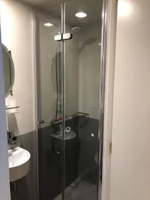a glass shower in a bathroom with a sink at Klipper Johanna in Monnickendam