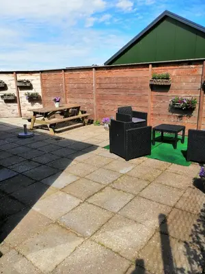 a patio with a picnic table and a bench at Knusse vakantiewoning in Camperduin in Schoorl