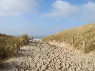 a dirt road leading to the ocean on a beach at Knusse vakantiewoning in Camperduin in Schoorl