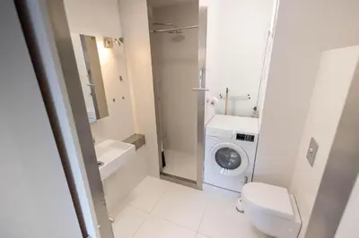 a bathroom with a toilet sink and a washing machine at Sterflat 83 in Egmond aan Zee