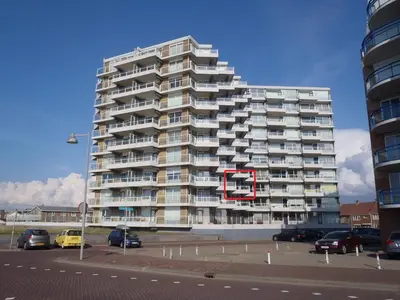 a tall apartment building with a red number on it at Sterflat 83 in Egmond aan Zee