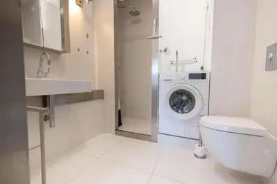a bathroom with a toilet and a washing machine at Sterflat 83 in Egmond aan Zee