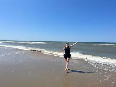 a woman walking on the beach at Vakantiehuis aan Zee (100 meter van het strand) in Egmond aan Zee