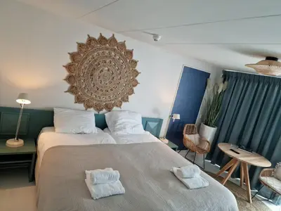 a bedroom with a large bed with towels on it at Hotel Liberte in Schoorl