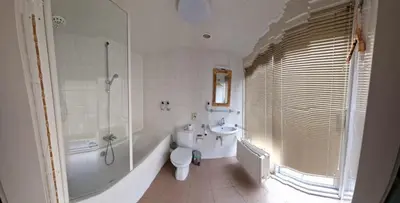 a bathroom with a tub and a toilet and a sink at Hotel Liberte in Schoorl