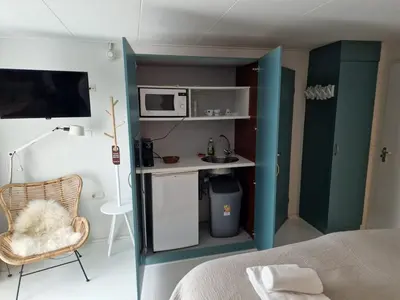 a small room with a bed and a microwave at Hotel Liberte in Schoorl
