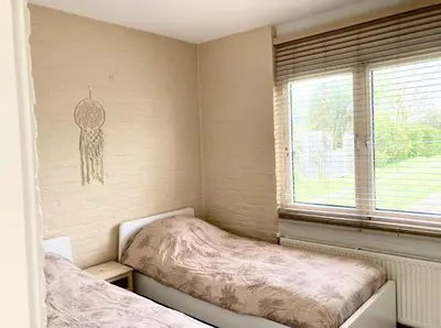 a bedroom with two twin beds and a window at NEW: Summerhouse near beach&lake in Noordwijkerhout