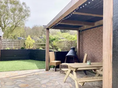 a patio with a picnic table and a grill at NEW: Summerhouse near beach&lake in Noordwijkerhout