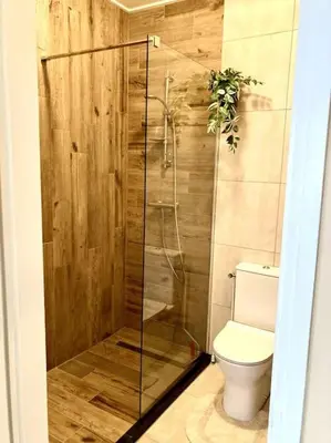 a bathroom with a toilet and a glass shower at NEW: Summerhouse near beach&lake in Noordwijkerhout