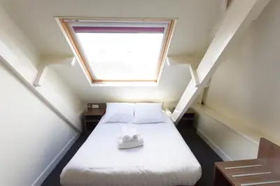 a small room with a bed with a window at Hotel Park Plantage in Amsterdam