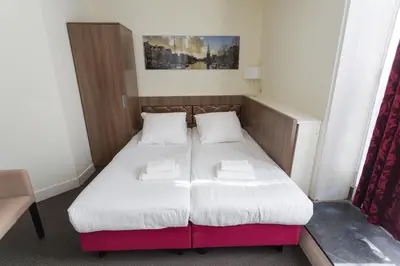a small bedroom with a bed with two pillows at Hotel Park Plantage in Amsterdam