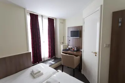 a hotel room with a bed and a desk at Hotel Park Plantage in Amsterdam