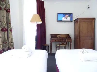 a hotel room with two beds and a tv on the wall at Hotel Park Plantage in Amsterdam
