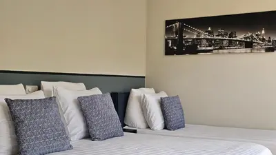 a bedroom with two beds with blue and white pillows at Guest Room Utrecht in Utrecht