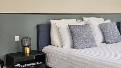 a bed with blue and white pillows on it at Guest Room Utrecht in Utrecht